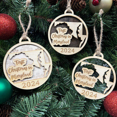 Maryland-shaped First Christmas in Maryland ornament hanging on a festive holiday tree with twinkling lights and lush greenery. A delightful keepsake to celebrate a special first Christmas in the Old Line State, capturing its coastal beauty and holiday cheer.
