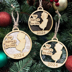 New Jersey-shaped First Christmas in New Jersey ornament hanging on a sparkling holiday tree with twinkling lights and lush greenery. A perfect keepsake to celebrate a special first Christmas in the Garden State, capturing its vibrant spirit and festive charm.