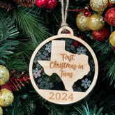 Texas-shaped First Christmas in Texas ornament hanging on a glowing holiday tree with twinkling lights and festive greenery. A perfect keepsake to celebrate a memorable first Christmas in the Lone Star State, reflecting its bold spirit and warm holiday cheer.