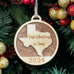 Texas-shaped First Christmas in Texas ornament hanging on a glowing holiday tree with twinkling lights and festive greenery. A perfect keepsake to celebrate a memorable first Christmas in the Lone Star State, reflecting its bold spirit and warm holiday cheer.