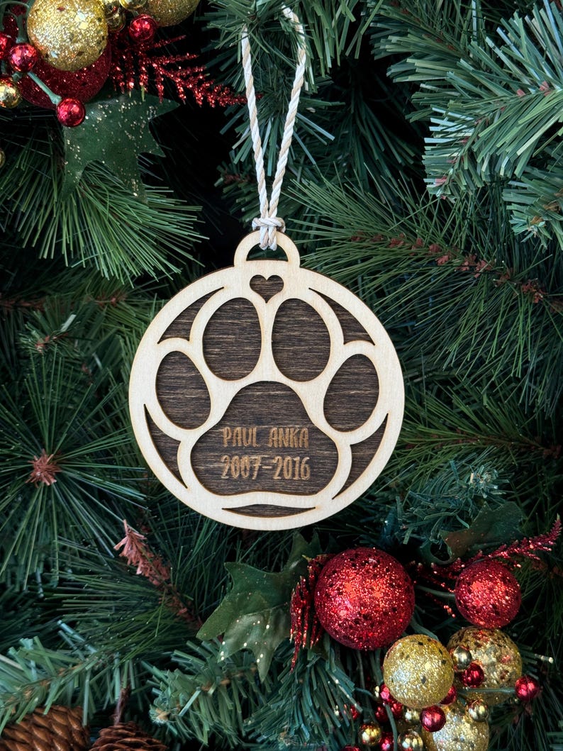 Ornament for Dog Lovers, featuring "Puppy's First Christmas" or a Pet Memorial design, shaped like a paw and personalized with your pet's name. A heartfelt keepsake to celebrate a new puppy’s first holiday or honor a cherished pet, adding a special and personalized touch to your Christmas tree.