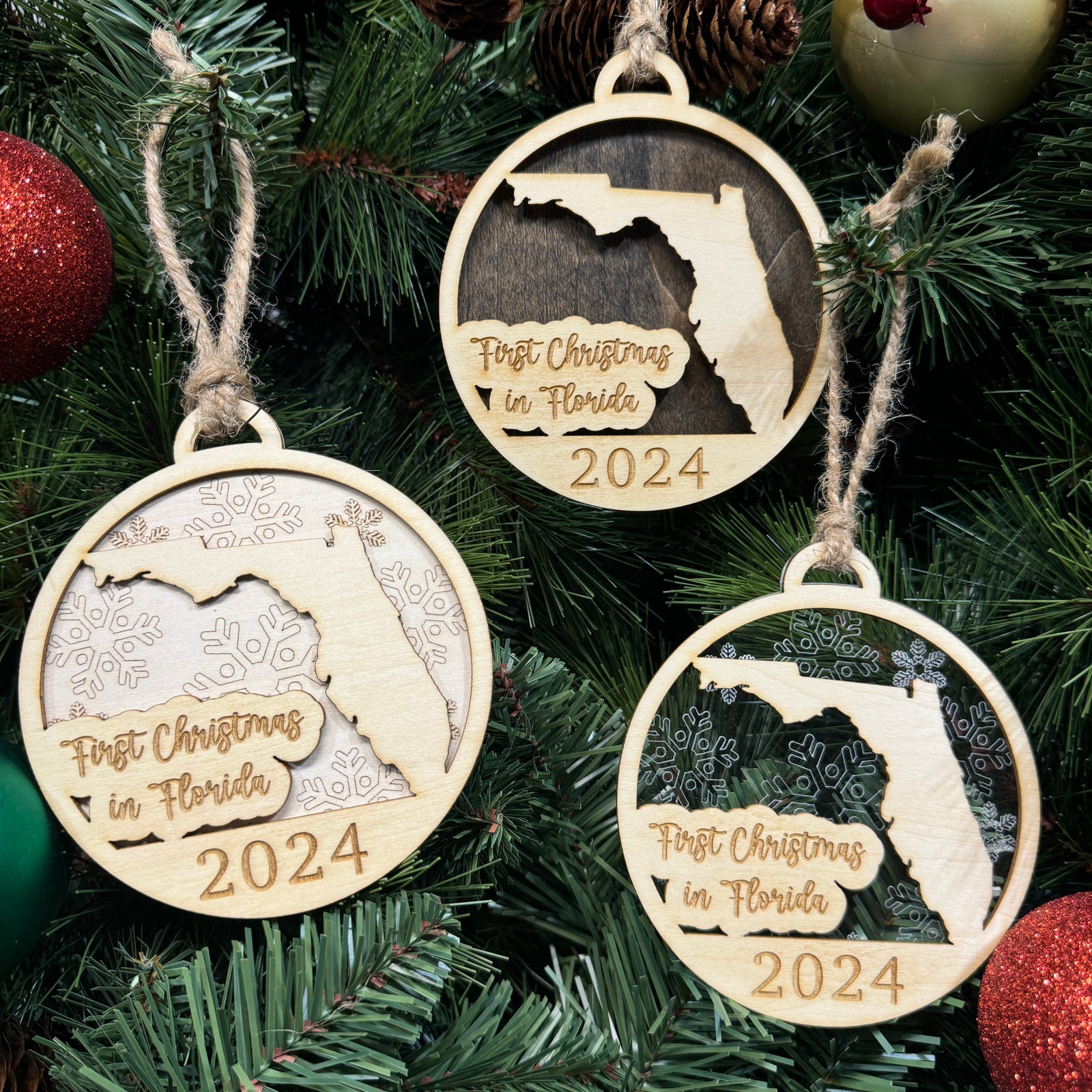 Florida-shaped First Christmas in Florida ornament hanging on a bright holiday tree with twinkling lights and tropical greenery. A perfect keepsake to celebrate a sunny and festive first Christmas in the Sunshine State.