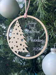 Baby's First Christmas Ornament featuring a festive Christmas tree design, personalized with baby’s name, year, and 'Baby’s First Christmas' text. A beautiful keepsake to celebrate a newborn’s first holiday season, perfect for adding a personal touch to Christmas trees and holiday decor.