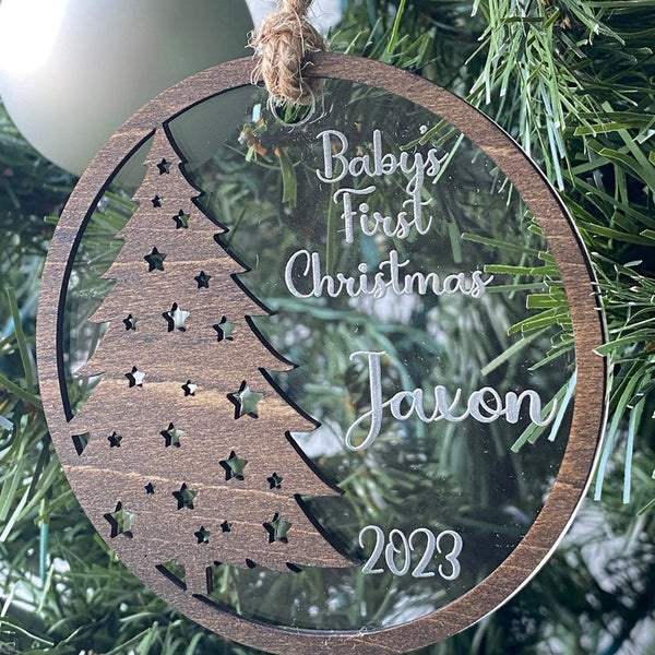 Baby's First Christmas Ornament featuring a festive Christmas tree design, personalized with baby’s name, year, and 'Baby’s First Christmas' text. A beautiful keepsake to celebrate a newborn’s first holiday season, perfect for adding a personal touch to Christmas trees and holiday decor.
