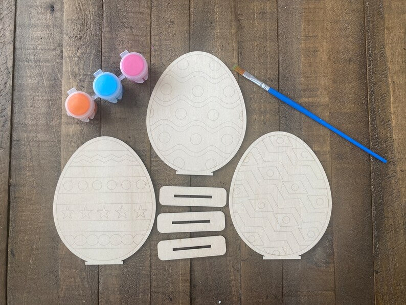 Paint Yourself Wood Easter Eggs, perfect for kids' Easter crafts. These wooden eggs come with stands and are ready to be painted, offering a fun and creative activity for children to celebrate the holiday. Ideal for Easter decorations or as personalized gifts.